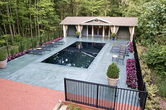 Aerial view of the uncovered Monte Carlo pool in Union Pier, with the pool house and woods behind