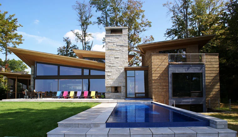 Custom pool and spa beside a modern stone and glass house in South Haven, MI