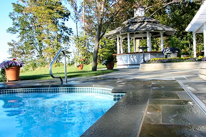 Bluestone ashlar deck around the curved end of a Dolphin pool in Benton Harbor, MI