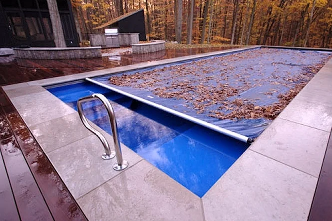 Automatic cover partly across a Luxor Deep pool, scattered with fall leaves