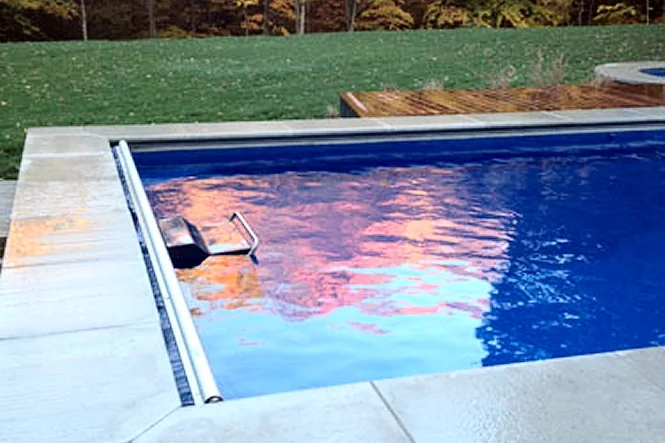 Sunset colors reflected in the water at the pool edge