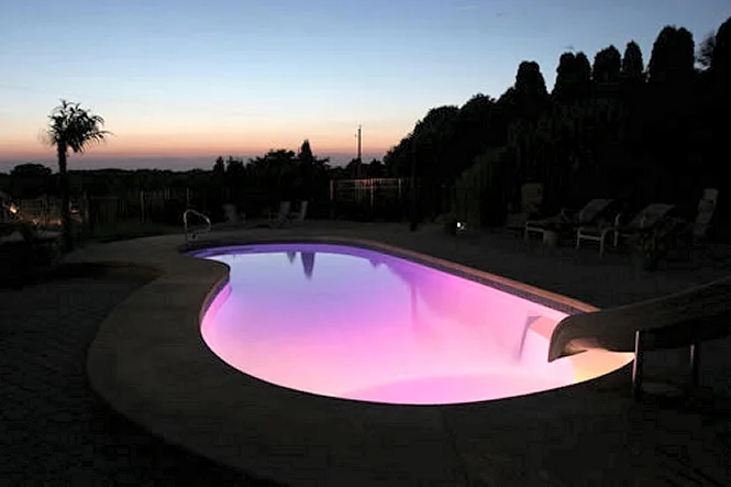 The pool glowing pink with color lighting at sunset
