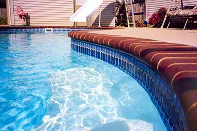 Close view of red brick coping and blue waterline tile