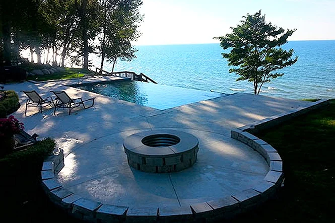 Vanishing edge pool and a round sunken fire pit on a bluff above Lake Michigan