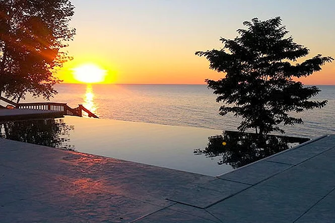 The sun setting over Lake Michigan beyond the vanishing edge of the pool
