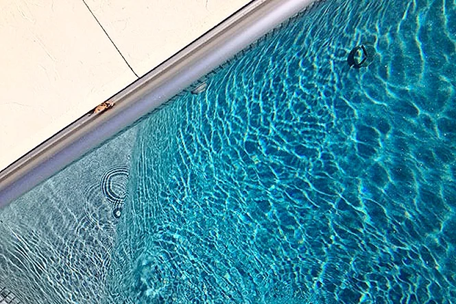 Close view of rippling water and the tile line along the pool edge