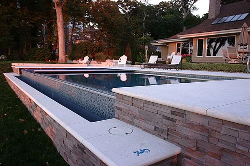 Raised stone wall at the end of the pool on the house side