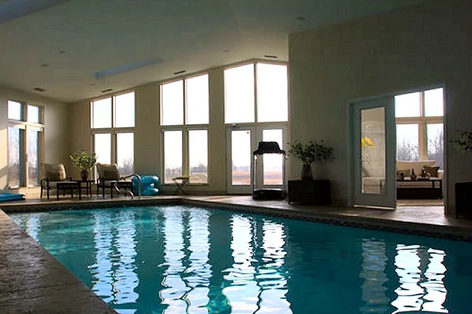 The indoor pool reflecting the tall windows