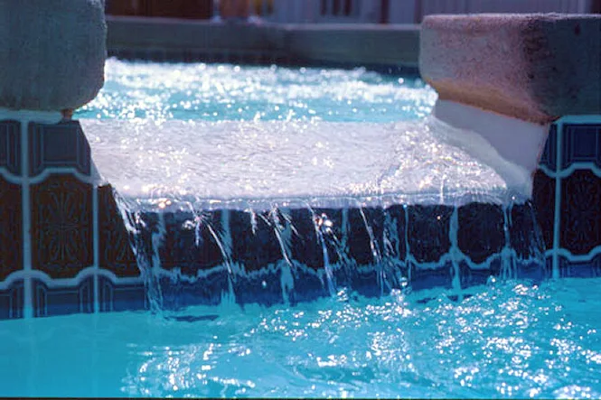 Water spilling from a raised spa into a Newport fiberglass pool in South Haven, MI