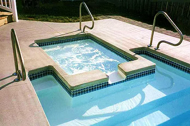 The spa and the seating area inside the pool, with two handrails