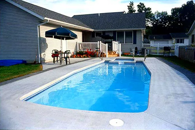 The pool from the deep end, with the house and patio umbrella behind