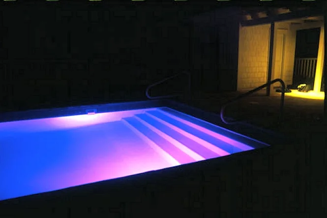 Pool steps glowing purple with fiber optic lighting at night