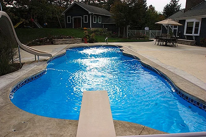 The freeform Taj Mahal Deep pool with a diving board in front and a slide behind