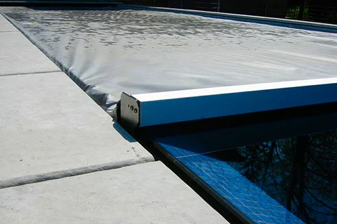 Close view of the automatic cover and its track at the pool edge