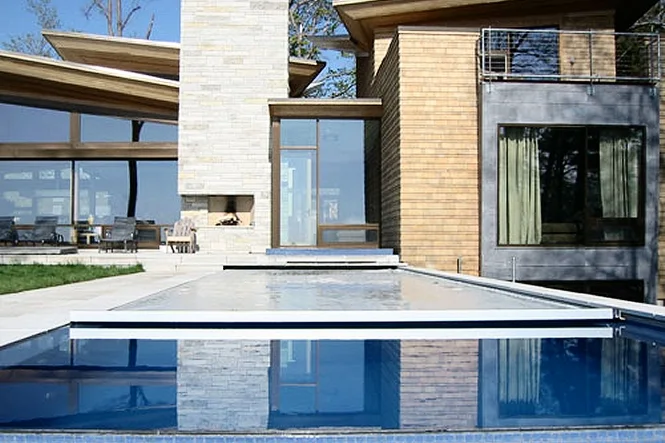 The automatic cover partly across the pool in front of the house